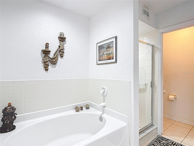 1628 Lullwater Ln, Lutz, FL 33549 - full bathroom with tile patterned floors, a shower stall, a garden tub, and a textured wall