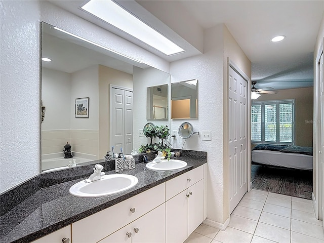 1628 Lullwater Ln, Lutz, FL 33549 - bathroom featuring a textured wall, tile patterned flooring, double vanity, baseboards, and recessed lighting