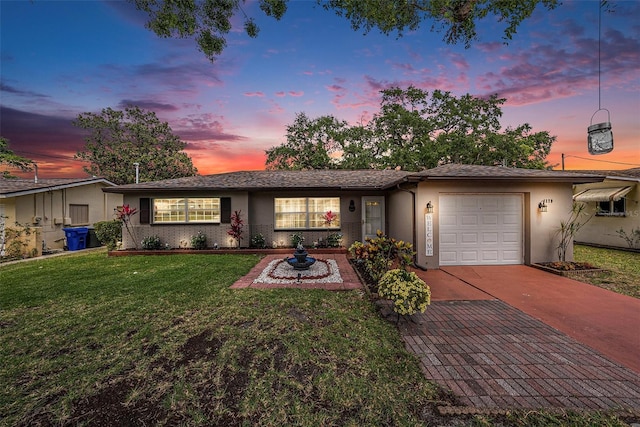 ranch-style house with a garage, concrete driveway, a yard, and stucco siding