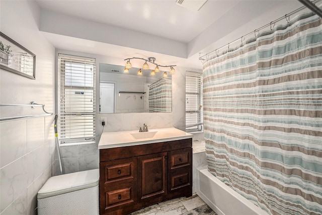 bathroom with tile walls, shower / tub combo with curtain, and vanity