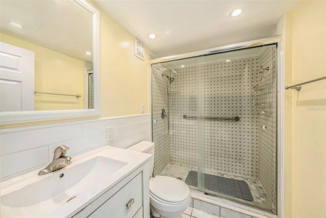 bathroom featuring a stall shower, toilet, recessed lighting, vanity, and tile walls