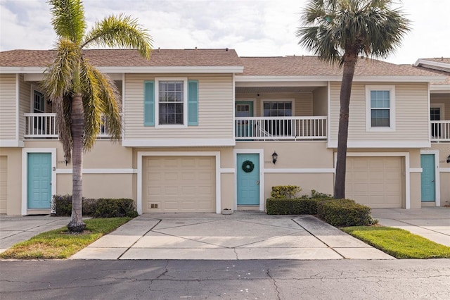 townhome / multi-family property featuring driveway, a garage, and stucco siding