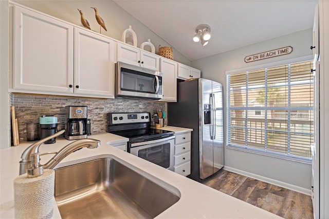 kitchen with stainless steel appliances, a sink, decorative backsplash, white cabinets, and light countertops