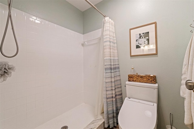 bathroom with tiled shower and toilet