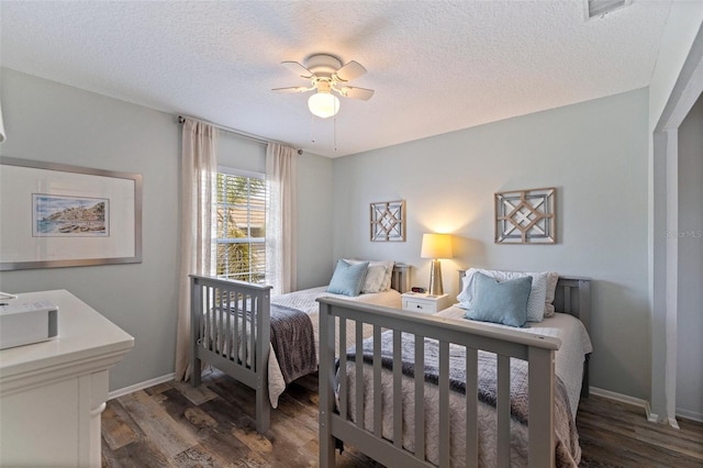 bedroom featuring wood finished floors, a textured ceiling, baseboards, and ceiling fan