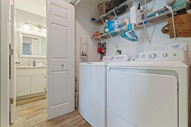 laundry room featuring light wood finished floors and washing machine and clothes dryer