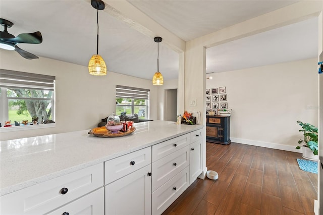 4600 Chancellor St NE, Saint Petersburg, FL 33703 - kitchen featuring light stone countertops, white cabinets, hanging light fixtures, baseboards, and dark wood-style flooring