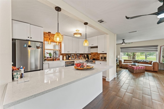 4600 Chancellor St NE, Saint Petersburg, FL 33703 - kitchen with appliances with stainless steel finishes, a sink, open floor plan, white cabinetry, and decorative backsplash