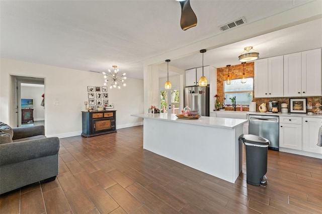 4600 Chancellor St NE, Saint Petersburg, FL 33703 - kitchen with appliances with stainless steel finishes, white cabinetry, light countertops, open floor plan, and a chandelier