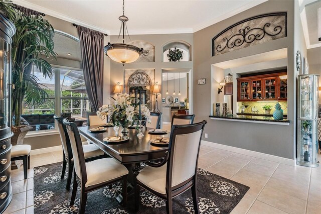 tiled dining space featuring ornamental molding and baseboards