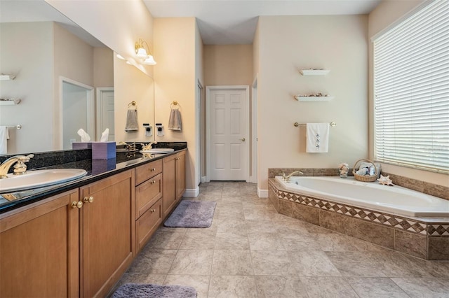 bathroom with plenty of natural light, a garden tub, and double vanity