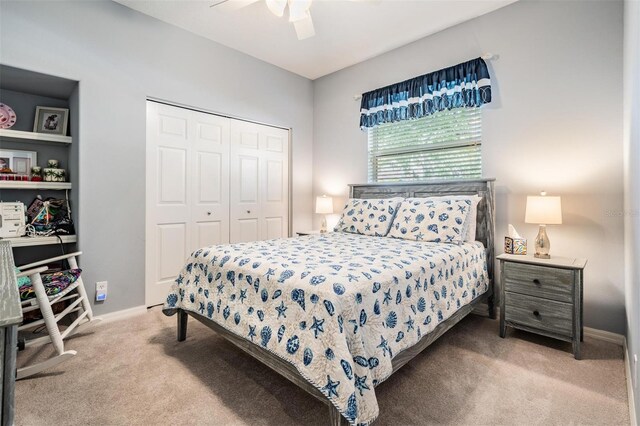 carpeted bedroom featuring a closet, baseboards, and ceiling fan