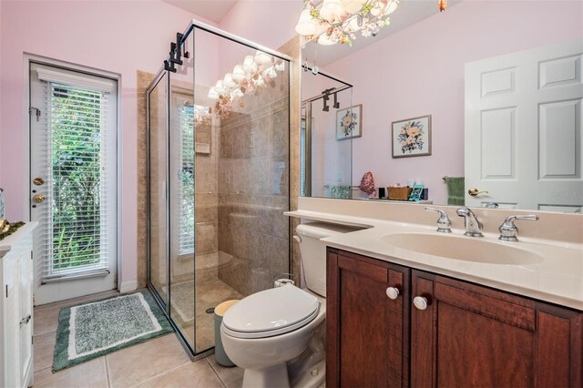 full bathroom featuring a chandelier, tile patterned floors, a shower stall, and vanity