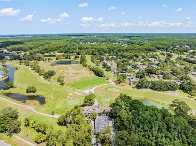 aerial view of property and surrounding area with a nearby body of water and a local golf course