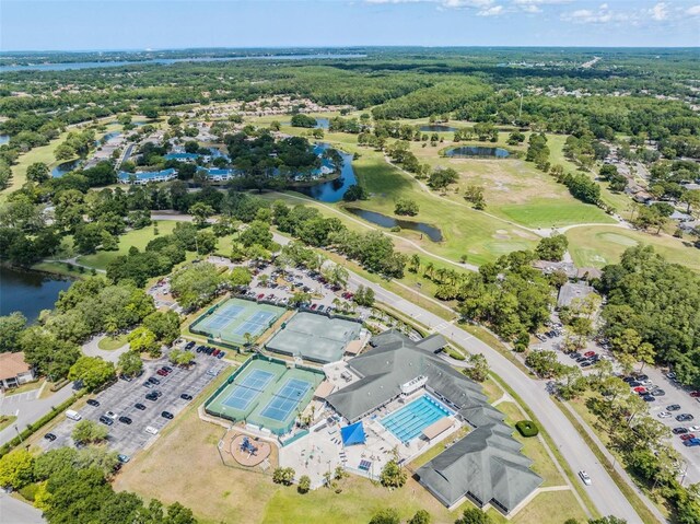 aerial view of property and surrounding area with a nearby body of water and a golf course