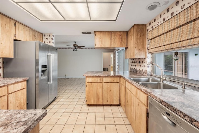 3230 Player Dr, New Port Richey, FL 34655 - kitchen featuring stainless steel appliances, a sink, light tile patterned floors, a peninsula, and a ceiling fan