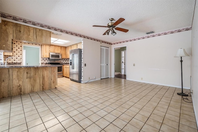 3230 Player Dr, New Port Richey, FL 34655 - kitchen featuring stainless steel appliances, a textured ceiling, ceiling fan, open floor plan, and a peninsula