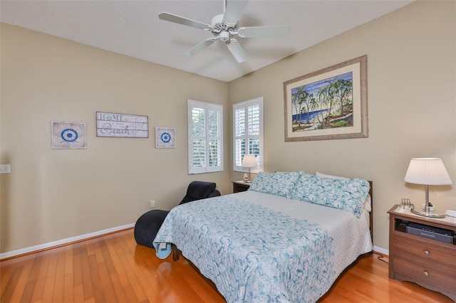 bedroom with wood finished floors, baseboards, and a ceiling fan