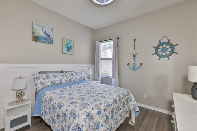 bedroom with dark wood-type flooring and baseboards