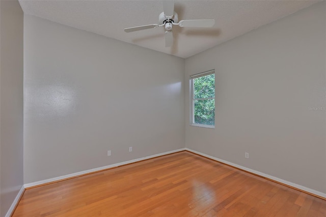 unfurnished room featuring wood finished floors, baseboards, and a ceiling fan