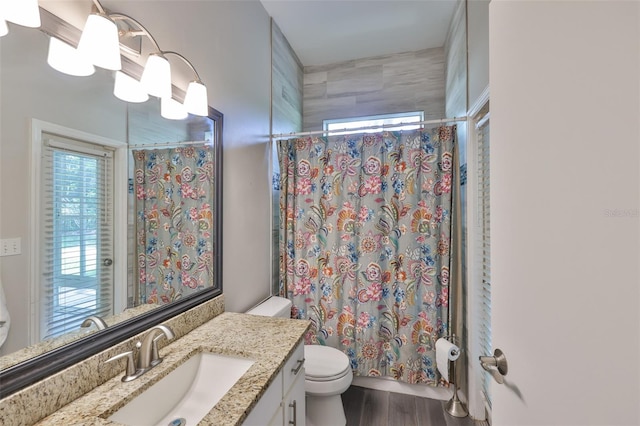 full bathroom with toilet, vanity, wood finished floors, and shower / tub combo with curtain