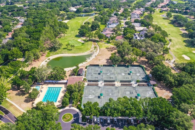aerial overview of property's location featuring a golf course, a large body of water, and a pool