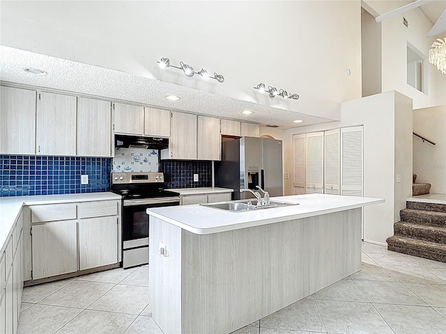 kitchen with stainless steel appliances, a sink, light tile patterned floors, ventilation hood, and light countertops