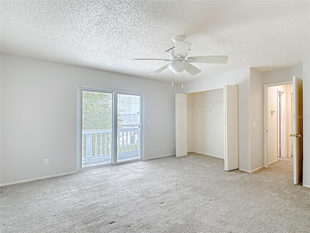 unfurnished bedroom featuring access to exterior, light colored carpet, a textured ceiling, a closet, and ceiling fan