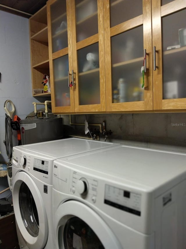 307 Druid Hills Rd, Temple Terrace, FL 33617 - laundry room with washing machine and clothes dryer, gas water heater, and cabinet space