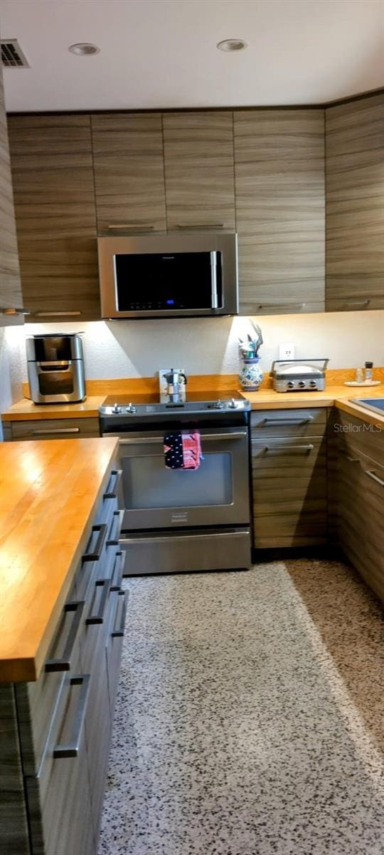 307 Druid Hills Rd, Temple Terrace, FL 33617 - kitchen with appliances with stainless steel finishes, butcher block counters, and recessed lighting