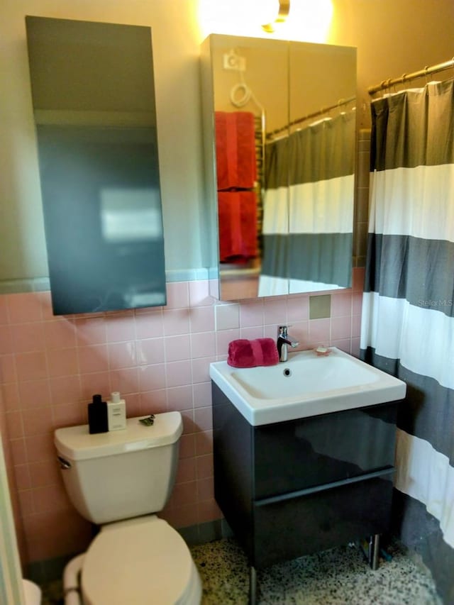 307 Druid Hills Rd, Temple Terrace, FL 33617 - bathroom with tile walls, toilet, vanity, a wainscoted wall, and a shower with shower curtain