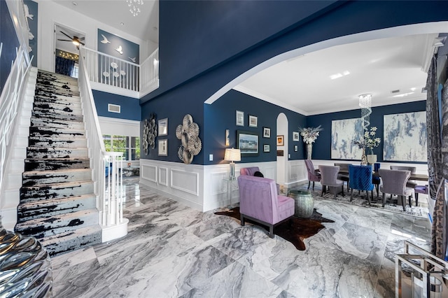 19620 Eagle Crest Dr, Lutz, FL 33549 - living area with arched walkways, a high ceiling, wainscoting, ornamental molding, and marble tiled flooring