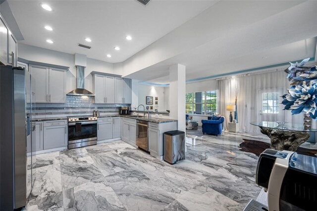 19620 Eagle Crest Dr, Lutz, FL 33549 - kitchen with stainless steel appliances, wall chimney range hood, decorative backsplash, light marble finish flooring, and recessed lighting
