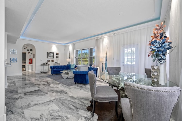 19620 Eagle Crest Dr, Lutz, FL 33549 - dining area featuring arched walkways, a tray ceiling, and marble tiled floors