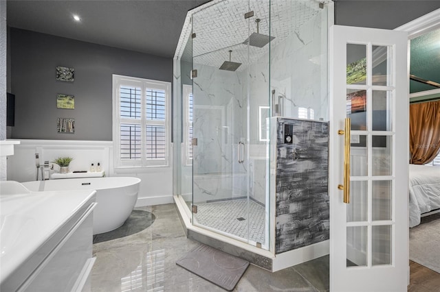 19620 Eagle Crest Dr, Lutz, FL 33549 - ensuite bathroom with a marble finish shower, a soaking tub, a wainscoted wall, and a decorative wall