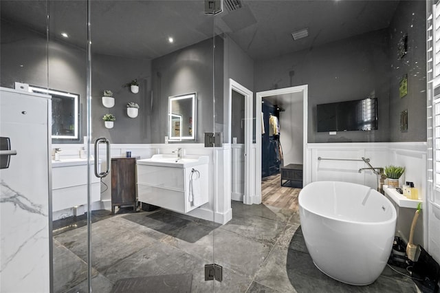 19620 Eagle Crest Dr, Lutz, FL 33549 - full bath with marble tiled flooring, vanity, a freestanding bath, wainscoting, and a shower stall