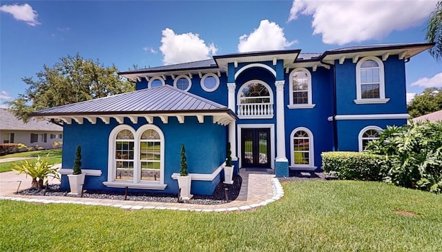 19620 Eagle Crest Dr, Lutz, FL 33549 - view of front of house with french doors, stucco siding, a front yard, and metal roof