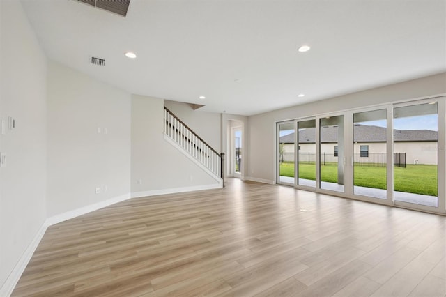 13137 Wellspring Dr, Lithia, FL 33547 - unfurnished living room with light wood-style floors, stairway, and recessed lighting