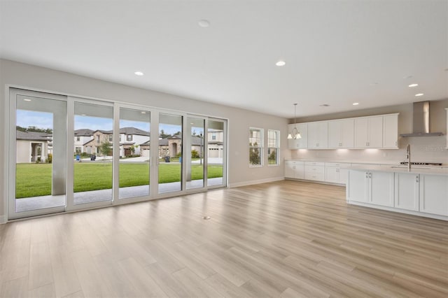 13137 Wellspring Dr, Lithia, FL 33547 - unfurnished living room with light wood-style flooring and recessed lighting