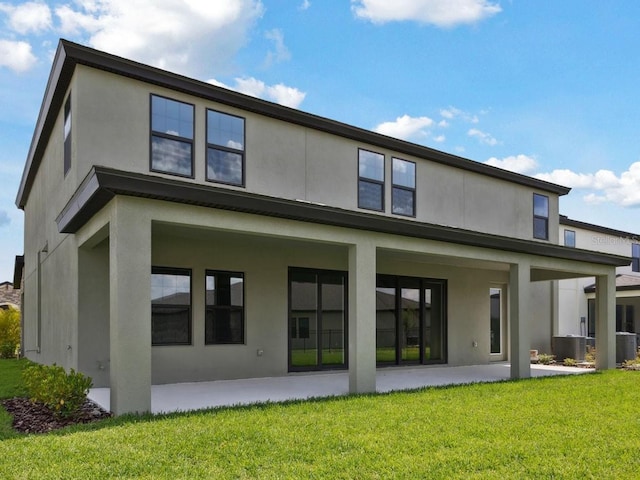 13137 Wellspring Dr, Lithia, FL 33547 - back of property featuring stucco siding, a patio area, and a yard