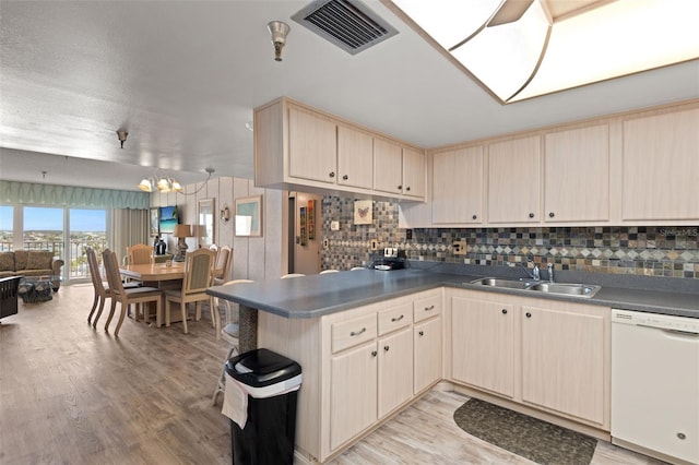 13440 Gulf Blvd Unit 501, Madeira Beach, FL 33708 - kitchen featuring dishwasher, a sink, light wood-style flooring, open floor plan, and a peninsula