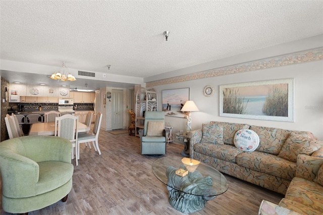 13440 Gulf Blvd Unit 501, Madeira Beach, FL 33708 - living area featuring a chandelier, a textured ceiling, and light wood-type flooring