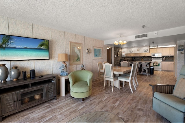 13440 Gulf Blvd Unit 501, Madeira Beach, FL 33708 - living area featuring a textured ceiling, a chandelier, and wood finished floors