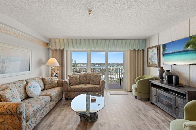 13440 Gulf Blvd Unit 501, Madeira Beach, FL 33708 - living room featuring a textured ceiling and light wood-style flooring
