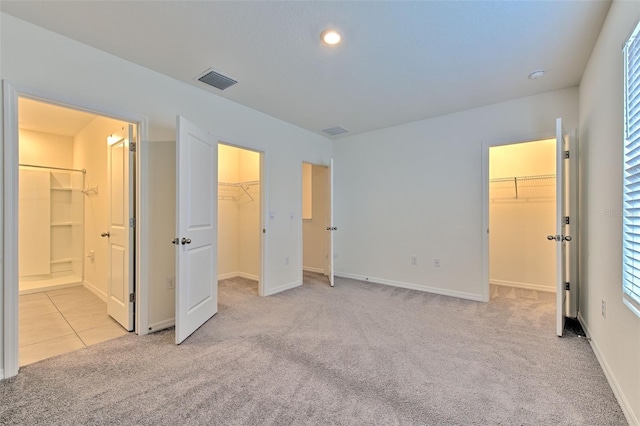 2882 Peony Prairie Ln, Wesley Chapel, FL 33543 - unfurnished bedroom featuring a walk in closet, carpet floors, a closet, connected bathroom, and recessed lighting