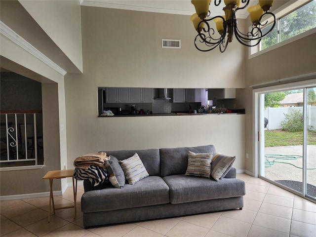 6906 Shady Pl, Tampa, FL 33634 - living room featuring light tile patterned floors, a towering ceiling, a chandelier, baseboards, and crown molding