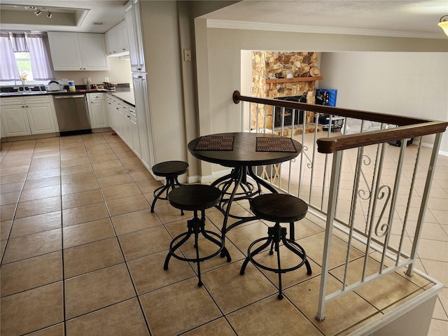 6906 Shady Pl, Tampa, FL 33634 - kitchen featuring dishwasher, dark countertops, light tile patterned flooring, ornamental molding, and white cabinets