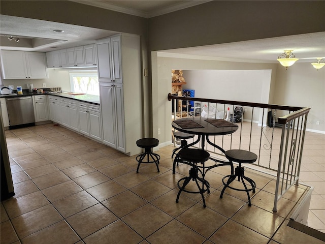 6906 Shady Pl, Tampa, FL 33634 - kitchen with stainless steel dishwasher, light tile patterned floors, crown molding, white cabinetry, and dark countertops