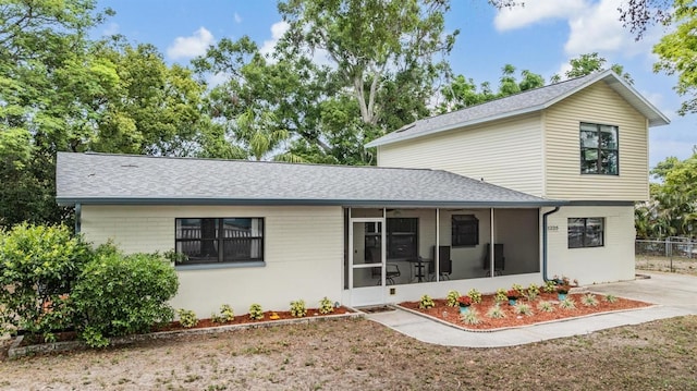 1225 15th St, Palm Harbor, FL 34683 - rear view of property featuring a sunroom, a shingled roof, and fence
