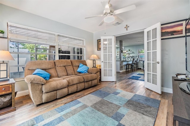 1225 15th St, Palm Harbor, FL 34683 - living area with french doors, ceiling fan, wood finished floors, baseboards, and a desk